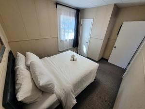 sypialnia z białym łóżkiem i oknem w obiekcie Lido Motel w mieście Radium Hot Springs