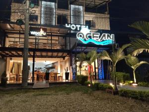富薩加蘇加的住宿－Hotel Ocean Fusagasuga，旁边有一个 ⁇ 虹灯标志的酒店