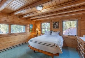 um quarto num chalé de madeira com uma cama e janelas em Buffalo Bliss by KABINO Riverfront Firepit Partial A/C Huge Views WiFi em Island Park