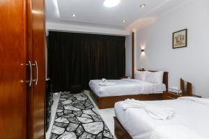 NEW ASSER HOTEL PYRAMID في القاهرة: غرفة فندقية بسريرين ونافذة