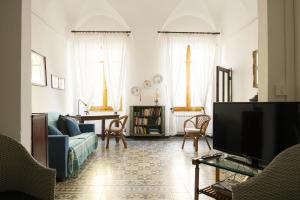 een woonkamer met een bank en een tv bij Arcani Family Apartment by Wonderful Italy in Finale Ligure