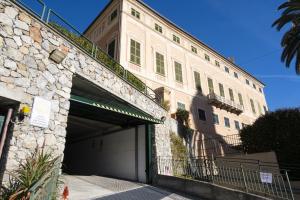 een groot stenen gebouw met een parkeergarage bij Arcani Family Apartment by Wonderful Italy in Finale Ligure