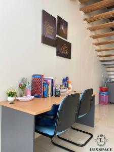 a desk with chairs and books on top of it at Cozy Kuching Samarahan Townhouse in Kota Samarahan