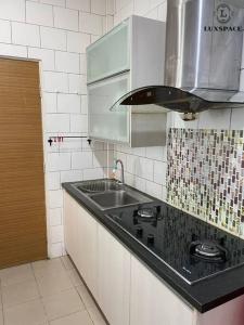 a kitchen with a sink and a counter top at Cozy Kuching Samarahan Townhouse in Kota Samarahan