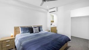 - une chambre dotée d'un grand lit avec des draps bleus dans l'établissement Harbor Haven Retreat, à Sandstone Point