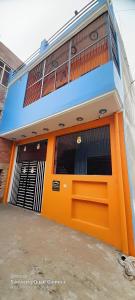 an orange door of a building with a garage at Shiv Niketan Guest House 200mtr from Shri Ram mandir in Ayodhya