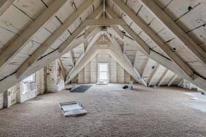 a large attic room with a ceiling with beams at Charming Retreat Near XU in Cincinnati