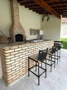 un patio con 4 sillas y una chimenea de ladrillo en Chacara casa de campo Condomínio fechado itupeva en Itupeva