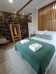 a bedroom with a large bed with towels on it at Casa do Poço in Santa Bárbara +82 photos