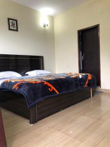a large bed in a bedroom with a wooden floor at 100 stairs holiday home in Mussoorie