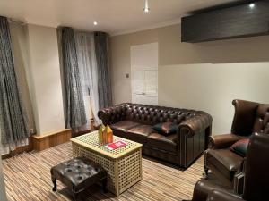 a living room with a leather couch and a table at Room 2 • Double Bed in Primrose Hill in London