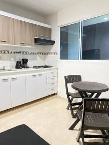 cocina con mesa y 2 sillas en Apartamento cómodo cerca al aeropuerto, en Cartagena de Indias