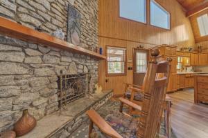 uma sala de estar com lareira de pedra numa casa em Lake Lure Retreat - A Beautiful Lakefront Lodge on Mirror Lake-Waterfront-Newly Expanded Deck lodge em Lake Lure