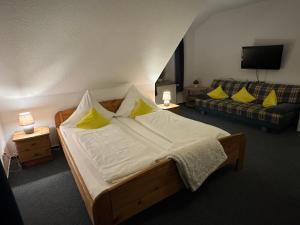 Alte Schmiede Hotel & Restaurant في جورك: غرفة نوم بسرير ومخدات صفراء واريكة