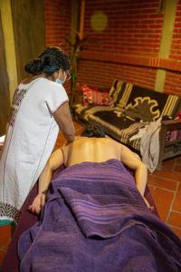 a woman standing next to a man laying on a bed at Huayápam Yù'ú Lodge in San Andrés Huayapan