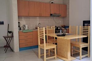 a kitchen with wooden cabinets and a table and chairs at Homestay In Maio - Room for Ladies, Couples & Families only, please in Calheta Do Maio