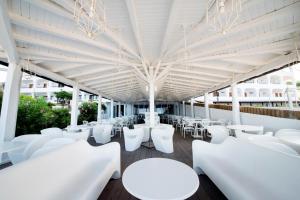 a room with white tables and white chairs at Hotel Oasi Di Kufra in Sabaudia