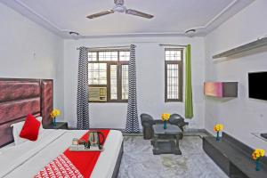 a living room with a bed and a tv at Flagship Cozy Stay Near Dilli Haat Ina in New Delhi