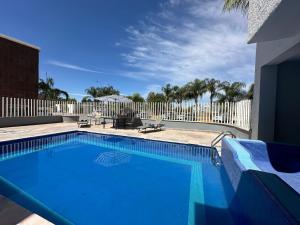 uma piscina azul com uma cerca branca e palmeiras em InHouse León em León