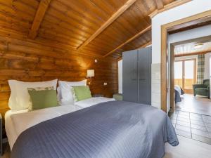 - une chambre avec un grand lit dans une pièce dotée de plafonds en bois dans l'établissement Chalet Kristall I, à Grossarl