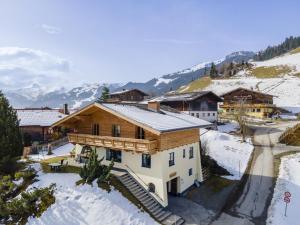 a house in the snow with mountains in the background at Chalet Kristall I in Grossarl