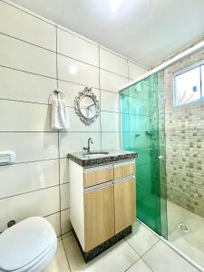 a bathroom with a shower and a toilet and a sink at MORADA GARAPEIRA in Guarda do Embaú