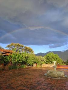 a stone fountain in a yard with trees and mountains at Huayápam Yù'ú Lodge in San Andrés Huayapan