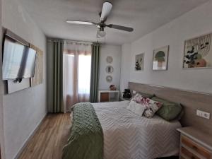 1 dormitorio con 1 cama y ventilador de techo en Costamar playa arenales del sol en Arenales del Sol