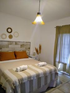 a bedroom with a bed with two towels on it at Hospedaje El Ciruelo in Alta Gracia