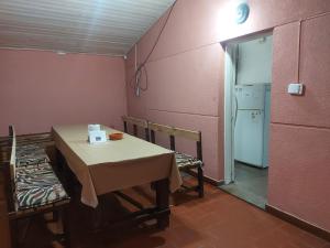 Habitación con mesa, sillas y nevera. en Verano infinito a 15' de Termas Guaychú, en Gualeguaychú