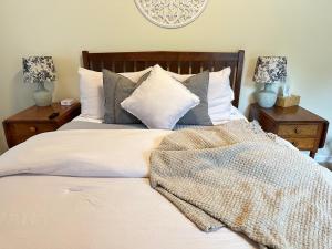 Schlafzimmer mit einem Bett mit weißer Bettwäsche und Kissen in der Unterkunft Letchworth Farm Guesthouses in Nunda