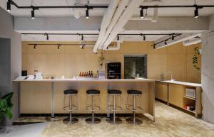 a kitchen with a island with bar stools at Markers Hostel in Gangneung
