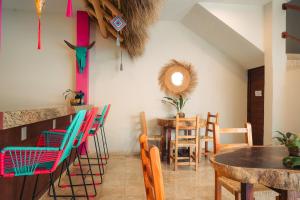 a dining room with colorful chairs and a table at Nuiya Hoteles Centro in Sayulita