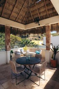 eine Terrasse mit einem Tisch und Stühlen auf einer Terrasse in der Unterkunft Nuiya Hoteles Centro in Sayulita
