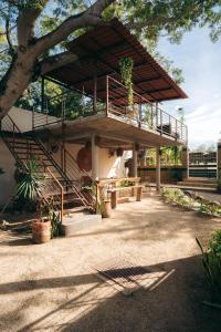 ein Gebäude mit einem Balkon und einem Baum in der Unterkunft Nuiya Hoteles Centro in Sayulita