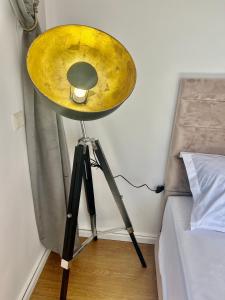 a yellow lamp on a tripod next to a bed at Baya House Sea View in Agadir