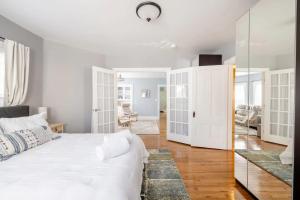 a bedroom with a white bed and a mirror at Bright Spacious Apartment - 2 BR 2 BA in Portland