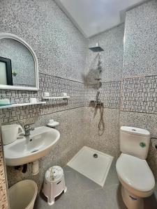Baya House Sea View في أغادير: حمام به مرحاض أبيض ومغسلة