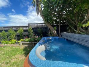 a large blue pool in a yard with at Oneroa Spa Retreat- Waiheke Escapes in Blackpool