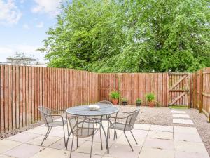 a patio with a table and chairs and a fence at Frater Place in Aberdeen