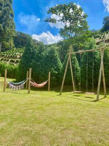 a couple of hammocks in a field with a mountain at Pousada Altitude 1200 in Fazendinha