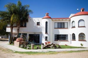 a white house with a palm tree in front of it at Casa del Horno in El Cinco de Mayo