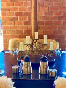 a table with tea pots and candles on it at Pousada Altitude 1200 in Fazendinha