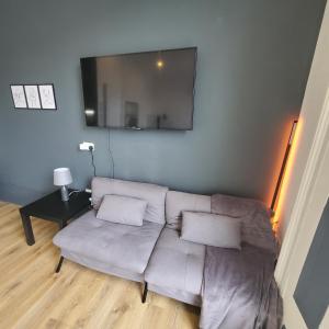 uma sala de estar com um sofá e uma televisão de ecrã plano em London Oasis Studio Apartment em Londres