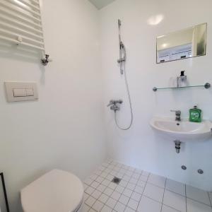 uma casa de banho branca com um WC e um lavatório em London Oasis Studio Apartment em Londres