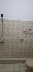 baño con aseo y pared de azulejos en Oyado Marufuku en Kandy