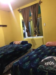 Habitación con 2 camas y espejo. en Hostal Candelaria en San Juan La Laguna