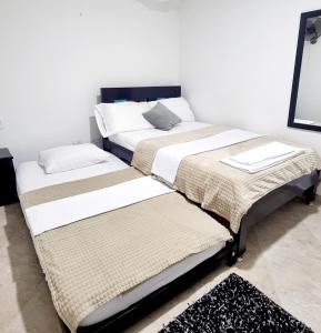 dos camas sentadas una al lado de la otra en una habitación en Hermosa casa en Bucaramanga, en Bucaramanga