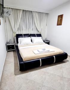 a bedroom with a large bed with a black headboard at Hermosa casa en Bucaramanga in Bucaramanga