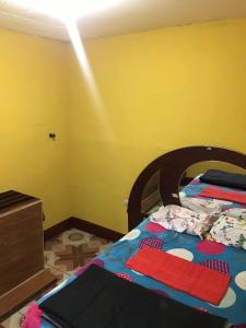 a bedroom with a bed and a yellow wall at Hostal Candelaria in San Juan La Laguna